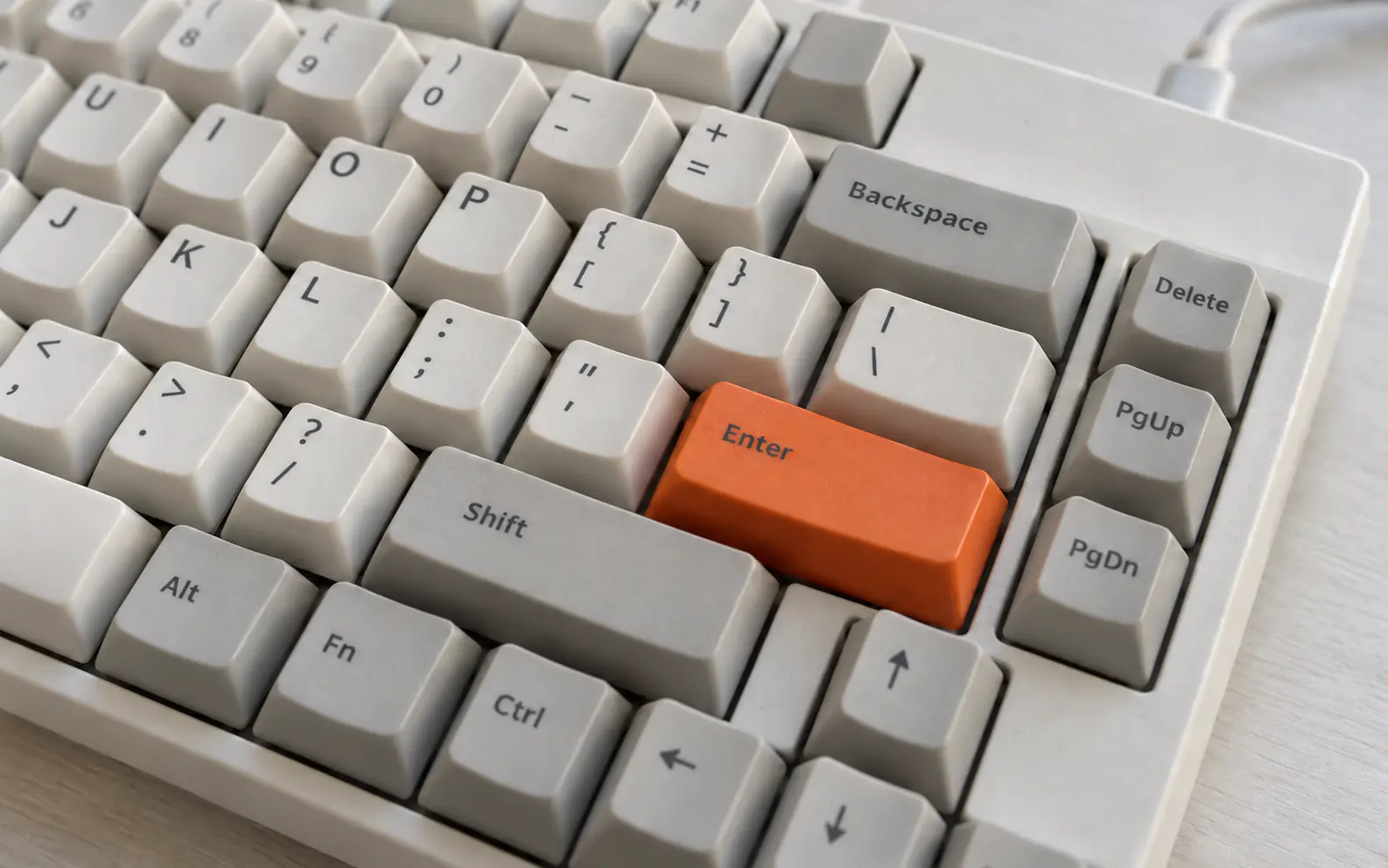 Nahaufnahme einer Tastatur mit orangefarbener Enter-Taste